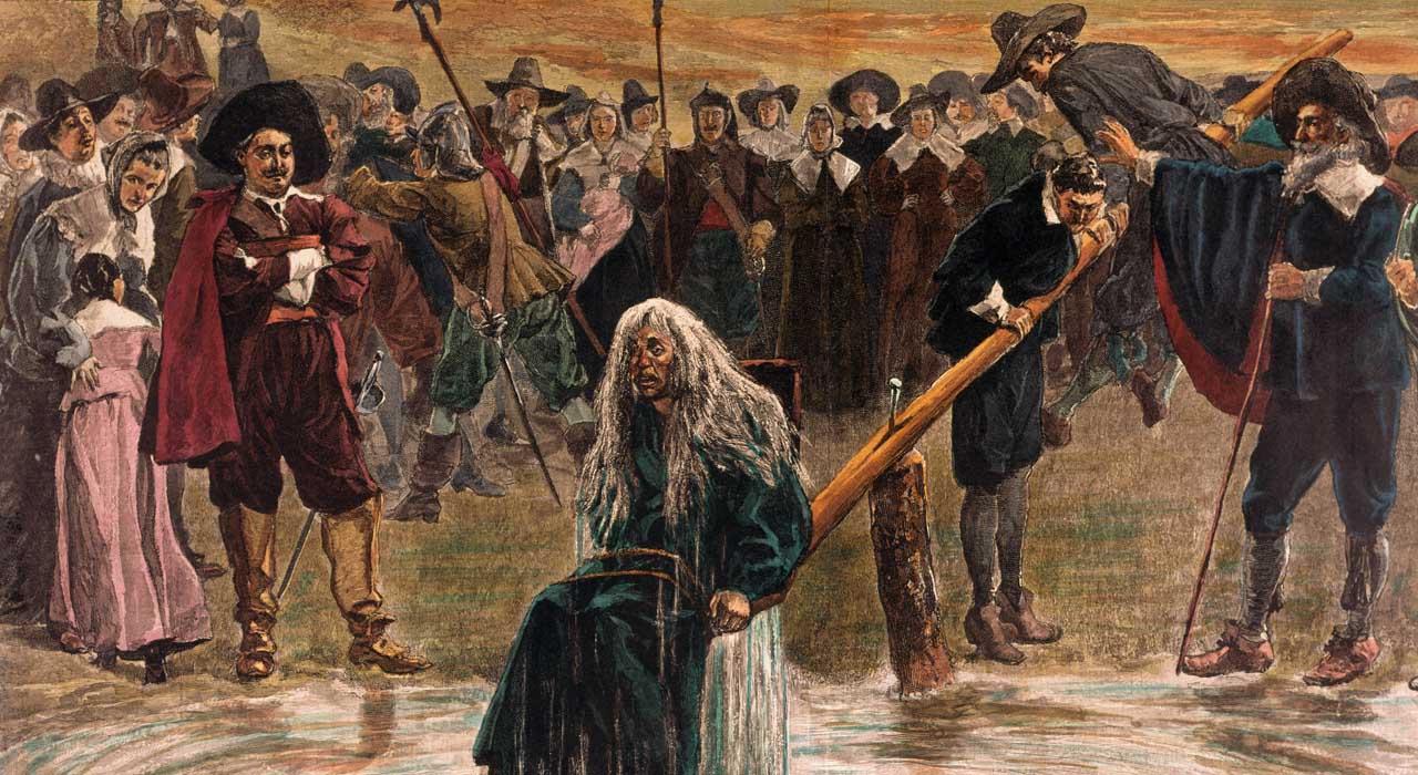 An accused witch going through the judgement trial, where she is dunked in water to prove her guilt of practicing witchcraft.